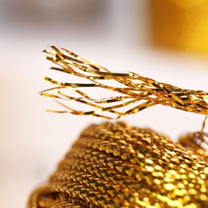 Macro shot of 1.5mm metallic gold braided thread for luxury gift wrapping and DIY crafts