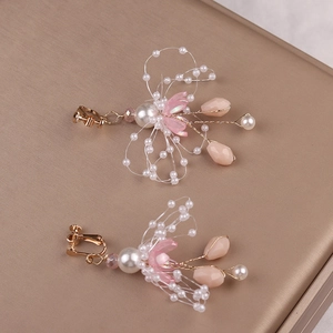 Detail von handgefertigten Blumen-Ohrclips mit rosa Perlen für kleine Mädchen