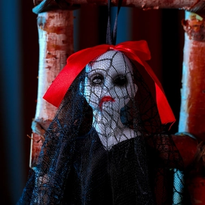 Creepy doll head with black mesh veil and red bow for Halloween haunted house decor