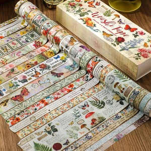 Macro shot of 20 rolls of vintage floral and butterfly washi tape on a wooden desk