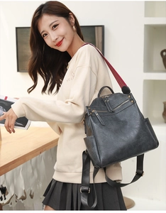 Detail view of black PU leather backpack with colorful woven strap on a female model