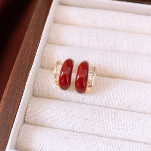 Detail of vintage red enamel semi-hoop earrings with gold finish and zircon stones