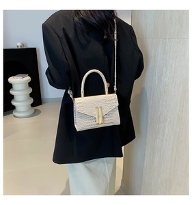 Chic beige crocodile pattern crossbody bag shown on a model in a modern interior