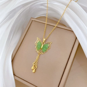 Elegant gold butterfly necklace with green jade stones and tassels on white silk