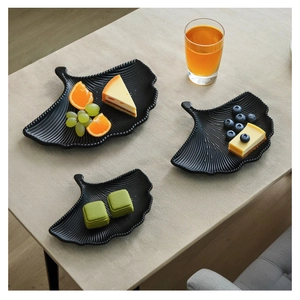 Detailed view of matte black ginkgo leaf plates with bionic veins for dessert serving