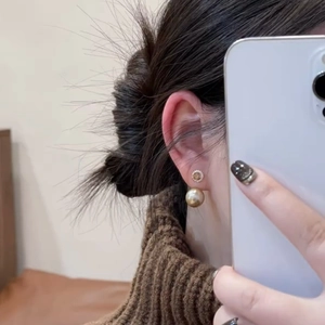 Detail of double-layer earrings with champagne pearl and zircon on model in mirror selfie
