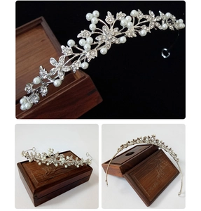 Detailed view of silver bridal crown with pearls and rhinestones on a jewelry box