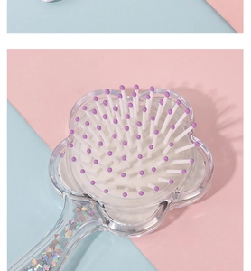 Detail of flower-shaped air cushion hairbrush with holographic silver sequins and purple beads