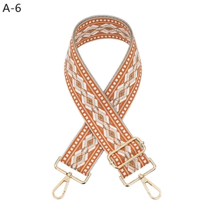 Detail of adjustable geometric diamond pattern bag strap with gold metal swivel hooks
