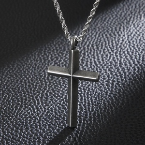 Retro silver cross pendant with twisted rope chain on black leather background
