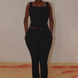 Detail view of black square neck tank top and slim fit trousers two-piece streetwear set