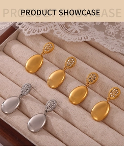 Detail of gold and silver double-layered oval earrings with crystals in a jewelry box
