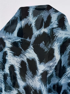 Dettaglio della trama del tessuto in chiffon leopardato con motivi blu scuro e neri