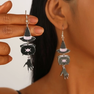Halloween witch hat and cauldron drop earrings with bone hand charms on model