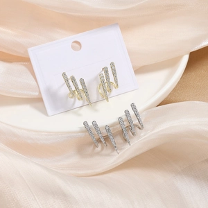 Minimalist gold and silver claw earrings featuring sparkling pavé cubic zirconia studs