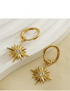 Detail of 18K gold plated sunflower earrings with cubic zirconia and starburst design