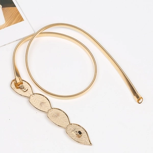Detail of golden metal spring belt featuring an elegant leaf-shaped buckle on white background