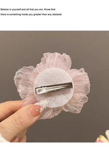 Vue détaillée de la pince à cheveux fleur en organza rose avec un fermoir en métal argenté