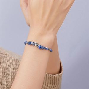 Detail eines handgefertigten Armbands mit unregelmäßigen blauen und grauen Natursteinen