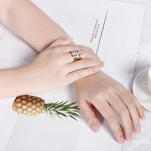 Close-up of three-piece titanium steel rings with Roman numerals on a hand model
