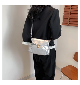Detailed back view of a metallic silver crossbody bag with a round gold lock and strap