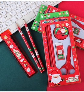 Christmas stationery set detail featuring pencils, ruler, and scissors on a desk