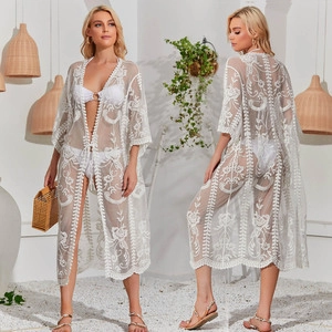 Detail of white lace beach cover-up featuring 3D floral embroidery and drawstring waist