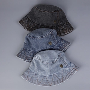 Detail of denim bucket hats with triangle stitching and metallic shield logo