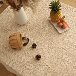 Bohemian lace tablecloth with geometric floral hollow patterns on a warm wooden table