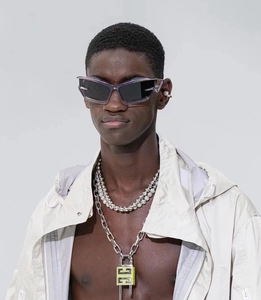 Model wearing futuristic purple sunglasses and silver metal padlock necklace