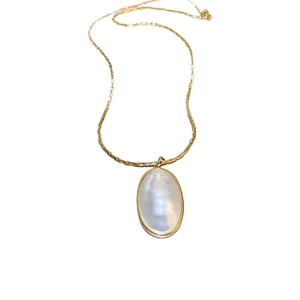 Collier doré style français avec pendentif perle ovale sur fond blanc immaculé
