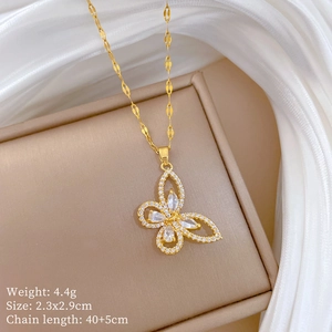 Detail view of gold hollow butterfly pendant necklace with cubic zirconia in a jewelry box