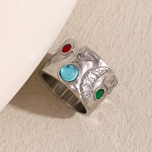 Détail de bague en acier argenté avec reliefs célestes et pierres précieuses colorées
