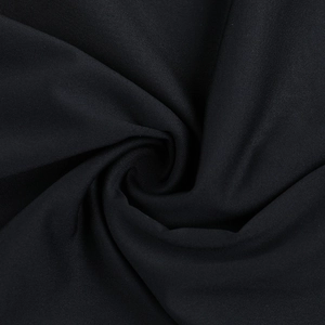 Macro shot of black textured mesh fabric with spiral folds for pleated dress detail