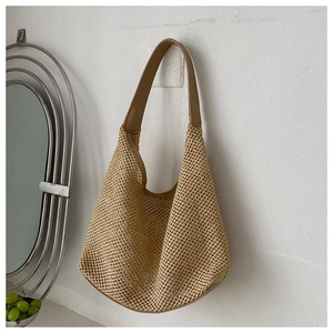 Detail of hollow mesh woven shoulder bag with wide faux leather strap in beige