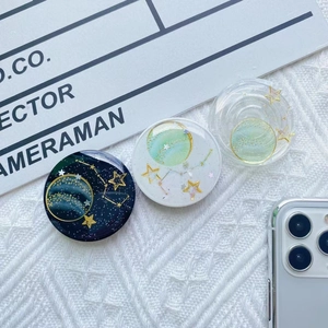 Detailed view of cosmic galaxy phone sockets with gold star sequins on lace surface