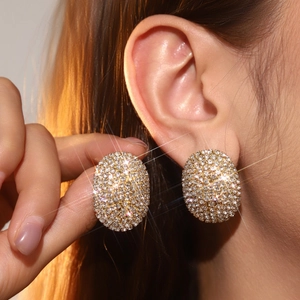 Boucles d'oreilles ovales pavées de strass pour femmes présentées sur l'oreille réelle