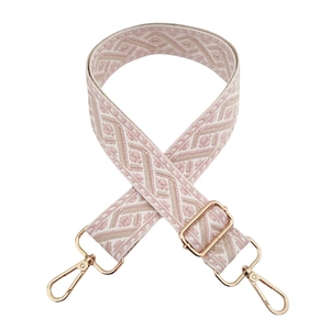 Pink and beige jacquard embroidery strap with golden metal clips on white background