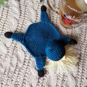 Detail of a handmade turtle crochet coaster with intricate navy and black knitting texture