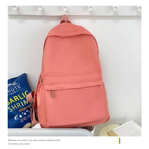 Close-up of coral pink backpack in minimalist style with large capacity for travel