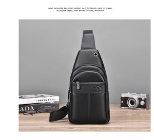 Detail of black leather chest bag featuring earphone port and front zipper on a desk