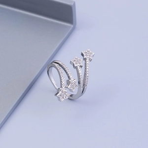 Detailed view of silver layered spiral ring with zircon-studded stars on purple background