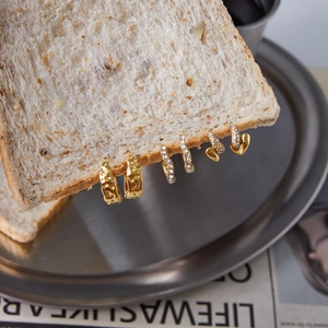 Creative display of 18K gold plated stainless steel hoop earrings on a bread slice