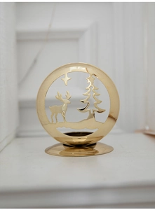 Detailed view of golden iron Christmas candle holder with deer and tree cutouts