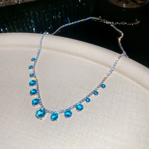 Macro shot of a silver necklace featuring blue gemstones and diamonds with sparkling star light
