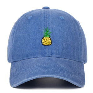 Close-up of a washed denim baseball cap with detailed yellow pineapple embroidery