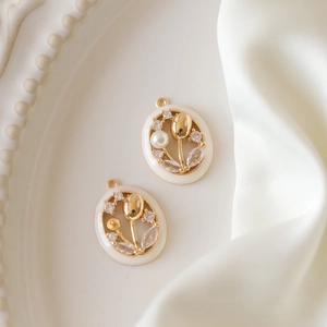 Detail view of tulip pendant with gold plating, white enamel, pearls and zircons