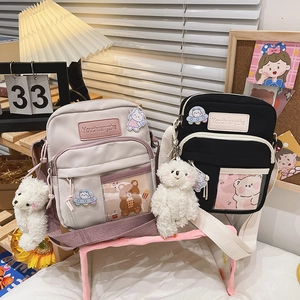 Détail du sac bandoulière en toile avec pin's ours astronaute et peluche