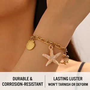 Macro detail of gold stainless steel chain bracelet with starfish and seashell charms