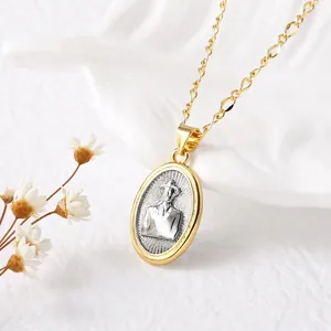Two-tone 18k gold plated Virgin Mary pendant necklace on white textured background